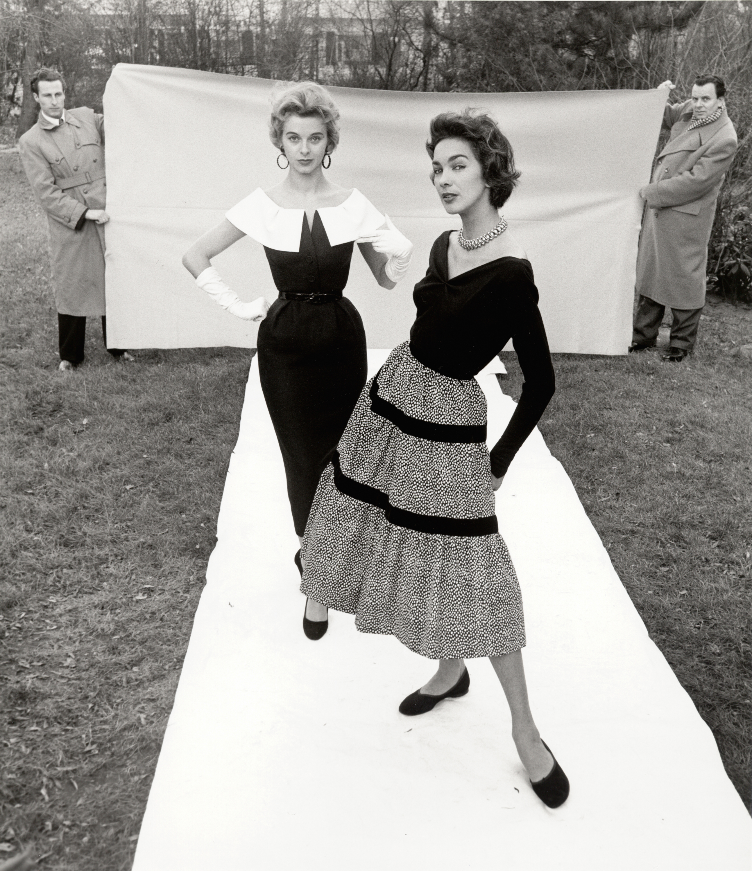 Foto: F.C. Gundlach, Candy Tannev und Elfi Wildfeuer, Chefredakteur Curt Waldenburger (“Film und Frau”) und sein Fahrer assistieren, Hamburg, 1954.